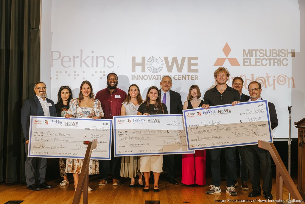HapWare CEO holding a giant check as a finalist in the Perkins School for the Blind pitch competition.